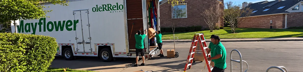 Oler Relo Moving Crew Unloading a Mayflower Trailer on a Local Move Oler Relo Moving crew unloading cartons from a Mayflower trailer outside a suburban home on a local move