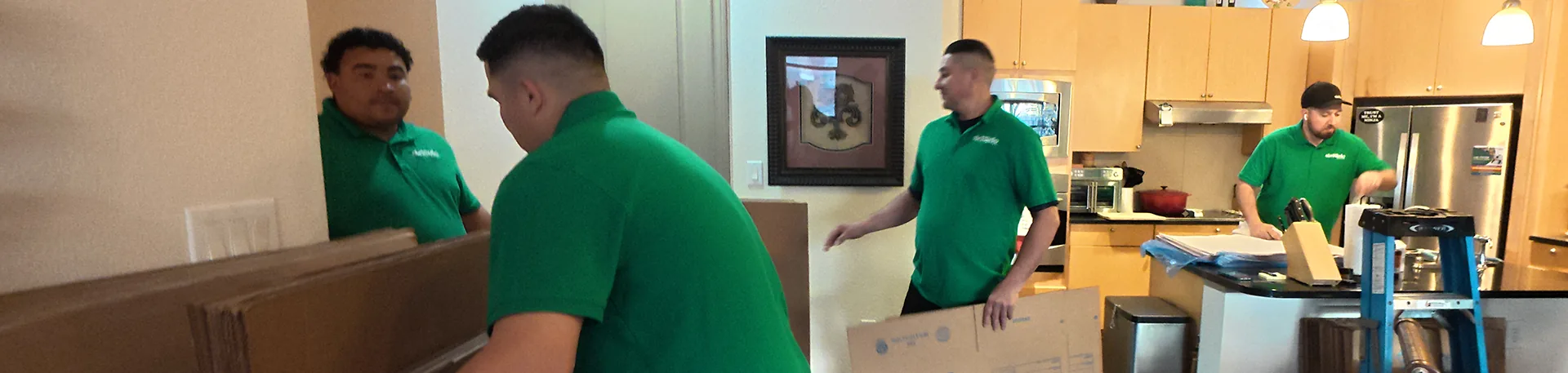 Oler Relo Moving Crew at Work | Interstate Moves Oler Relo Moving crew packing and carrying a wrapped picture frame during an interstate move
